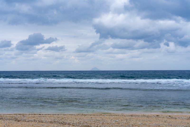 Dinem Island peeking through the horizon. Taken from Maydangeb.