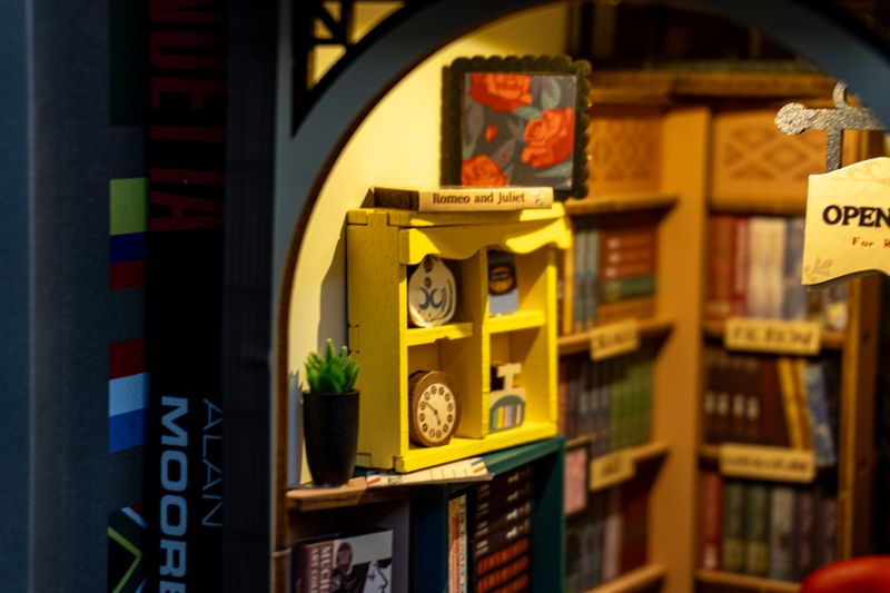 A close-up on the left details. The post under the yellow bookshelf and the Romeo and Juliet cover are the only stickers. Everything else is printed on fiberboard.
