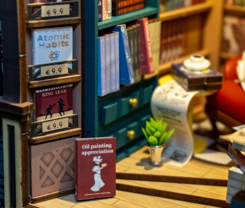 The scroll under the coffee table is also a long sticker with a precise placement. Atomic Habits makes a cameo in the piece.
